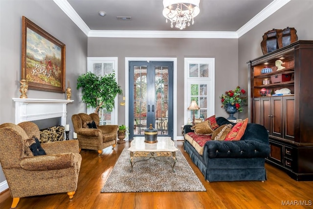 sitting room with visible vents, ornamental molding, wood finished floors, french doors, and a notable chandelier