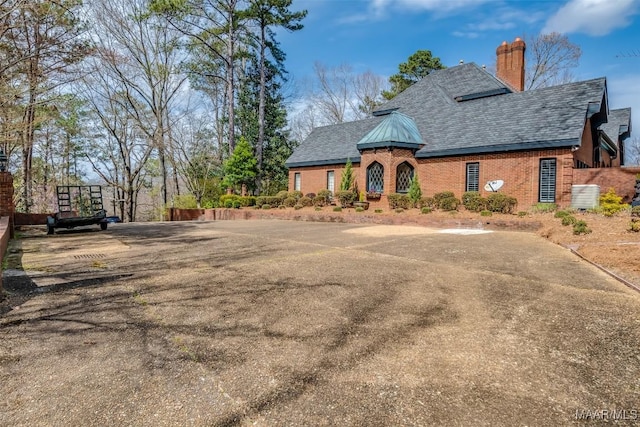 view of front of house with a chimney and brick siding