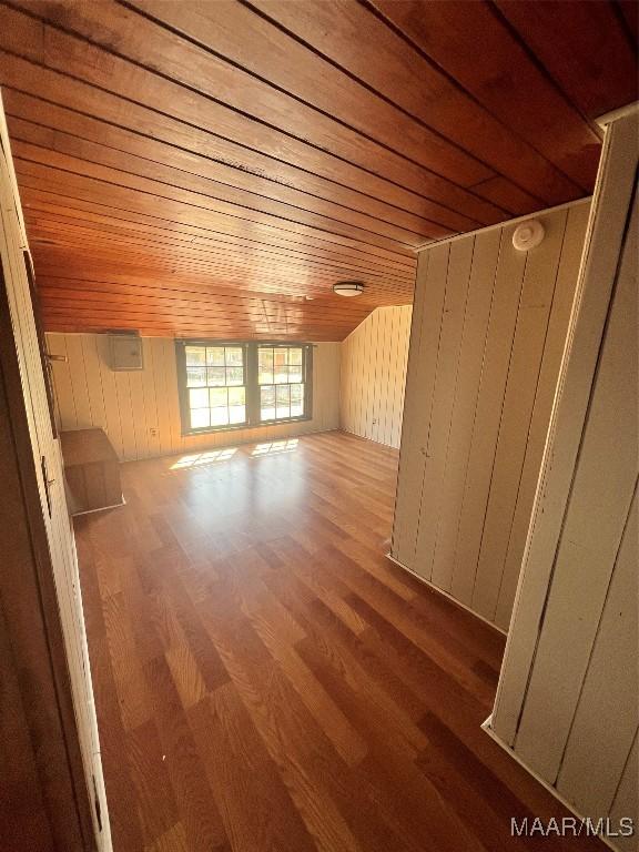 bonus room with wooden ceiling, wood finished floors, and wood walls