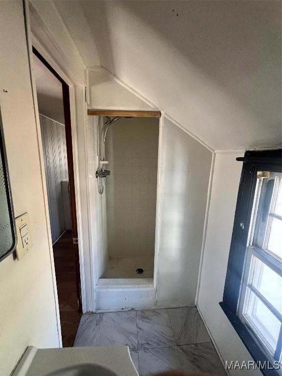 full bath featuring marble finish floor and a stall shower