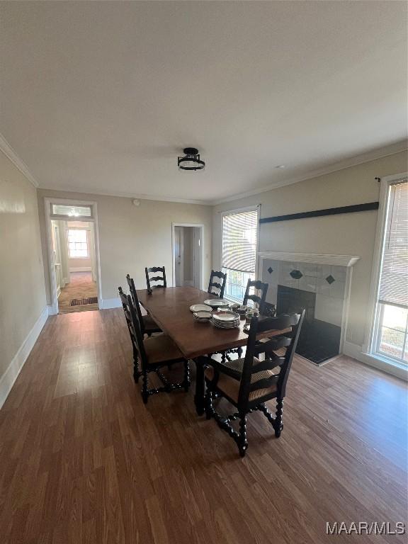 dining space with plenty of natural light, crown molding, baseboards, and wood finished floors