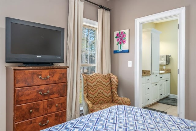 bedroom with tile patterned flooring and connected bathroom