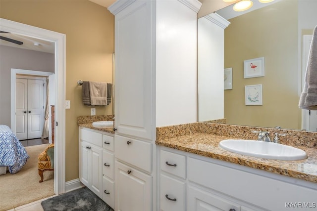 ensuite bathroom featuring connected bathroom, ceiling fan, and vanity