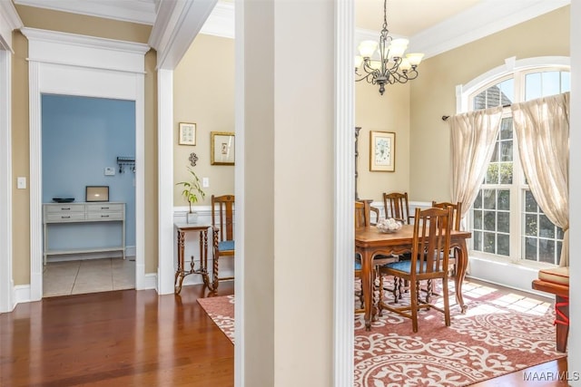 dining area featuring wood finished floors, an inviting chandelier, and ornamental molding