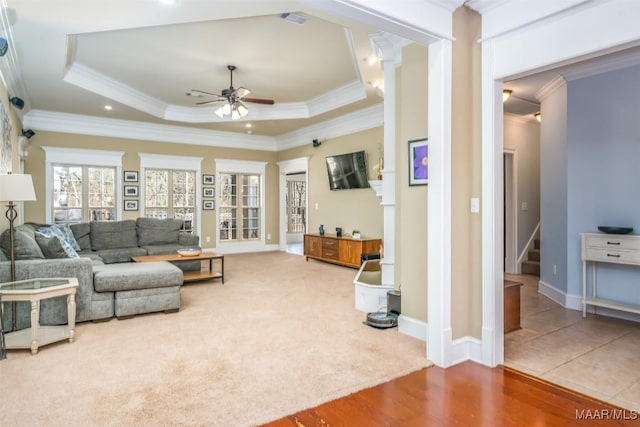 living room featuring visible vents, crown molding, a raised ceiling, and ceiling fan