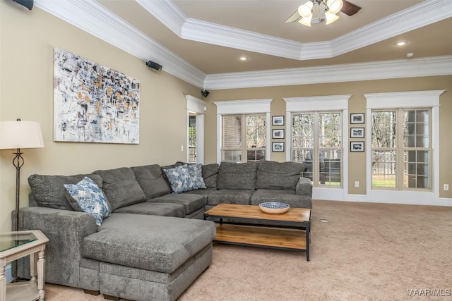 carpeted living area with recessed lighting, a raised ceiling, a ceiling fan, and ornamental molding