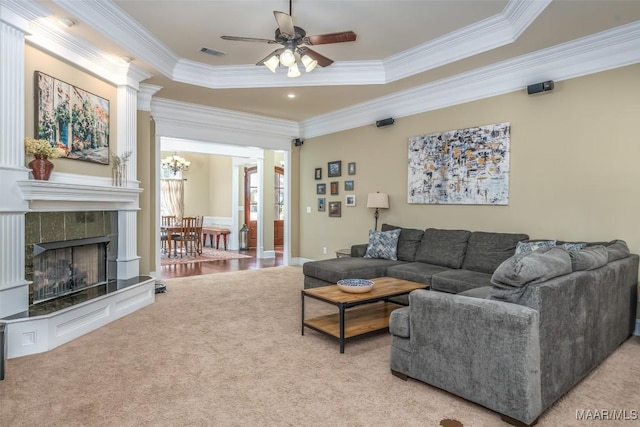 living room featuring visible vents, light colored carpet, a tray ceiling, and ornamental molding