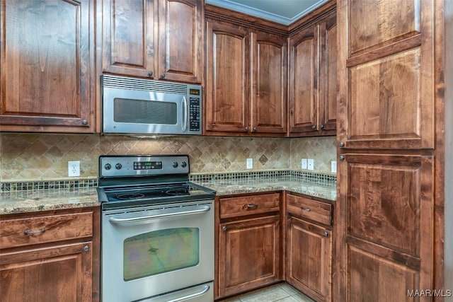 kitchen with decorative backsplash, light tile patterned flooring, light stone countertops, and stainless steel appliances