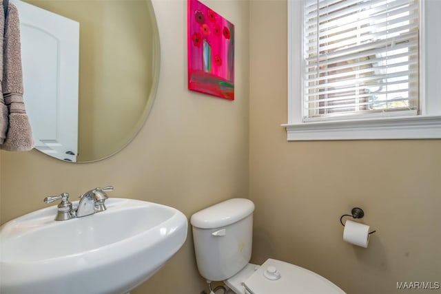 half bathroom featuring toilet and a sink