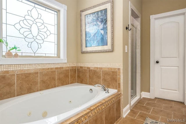 bathroom with tile patterned floors, a tub with jets, and a stall shower