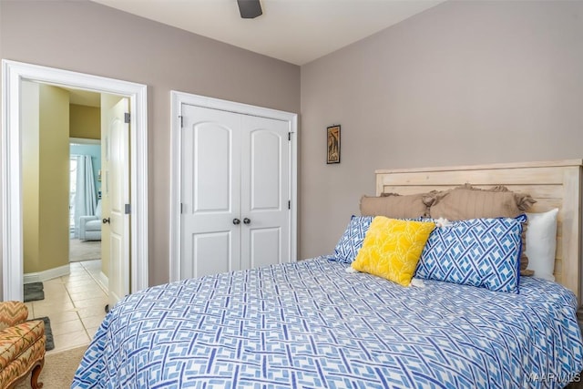 bedroom with tile patterned floors, ceiling fan, baseboards, and a closet