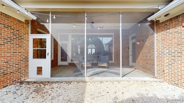 entrance to property featuring a patio and brick siding