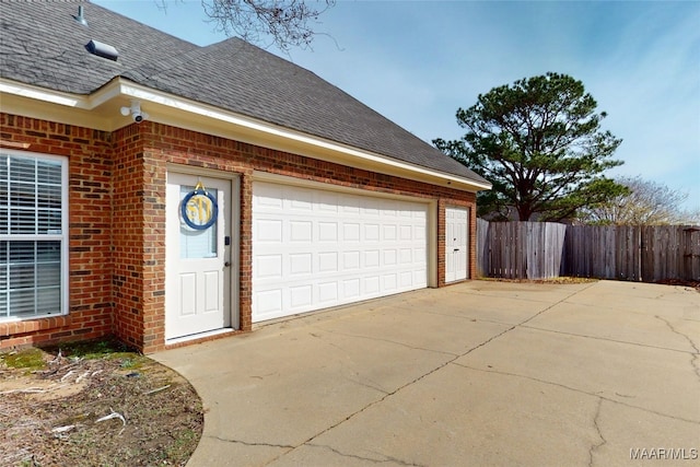 garage with driveway and fence