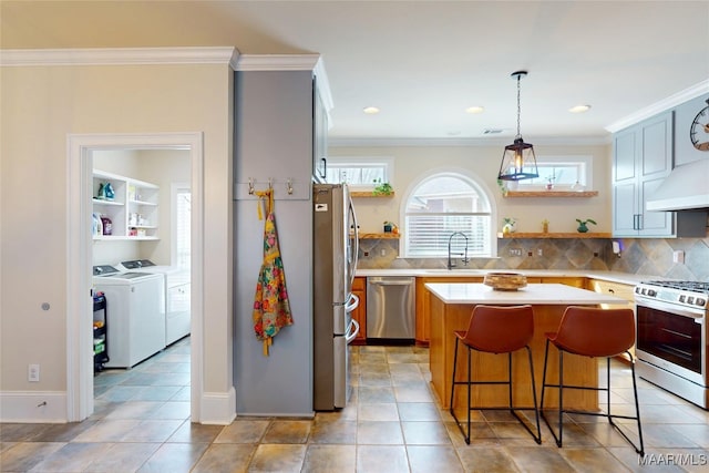 kitchen with open shelves, washer and clothes dryer, light countertops, appliances with stainless steel finishes, and a sink