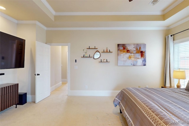 carpeted bedroom with baseboards, a tray ceiling, and ornamental molding