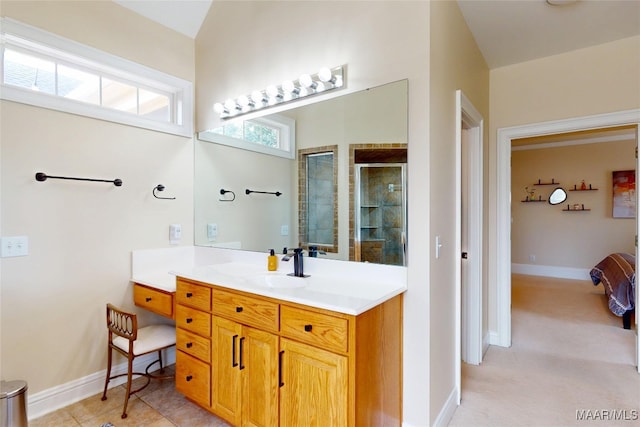 bathroom featuring vanity, tile patterned floors, baseboards, and a stall shower