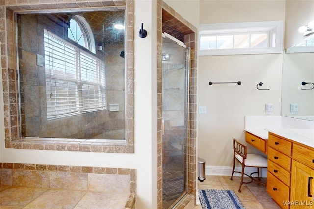 bathroom featuring a wealth of natural light, baseboards, a stall shower, and vanity