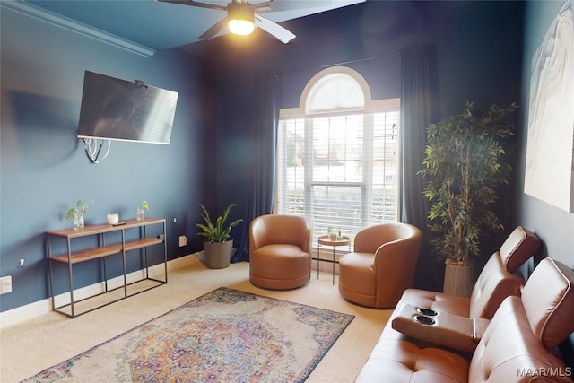 sitting room featuring baseboards, carpet, and a ceiling fan