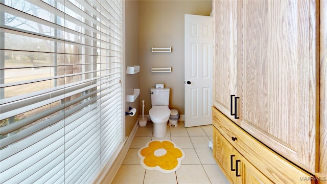 bathroom with tile patterned floors, toilet, and baseboards