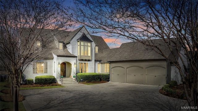 view of front of home featuring roof with shingles, concrete driveway, and an attached garage