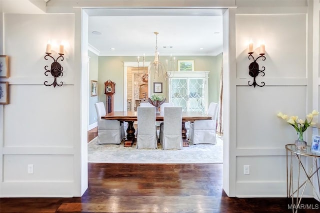 dining room featuring wood finished floors, baseboards, and ornamental molding