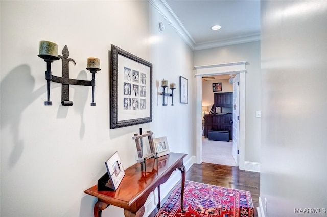 corridor featuring wood finished floors, baseboards, ornamental molding, and recessed lighting