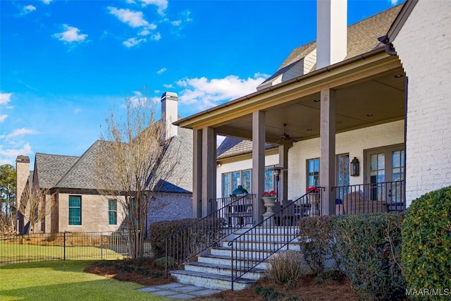 exterior space with fence, roof with shingles, and a chimney