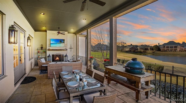 sunroom / solarium featuring ceiling fan and a fireplace