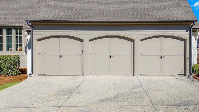 garage featuring concrete driveway