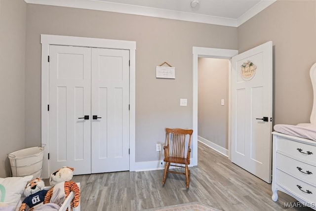 sitting room featuring crown molding, light wood-type flooring, and baseboards