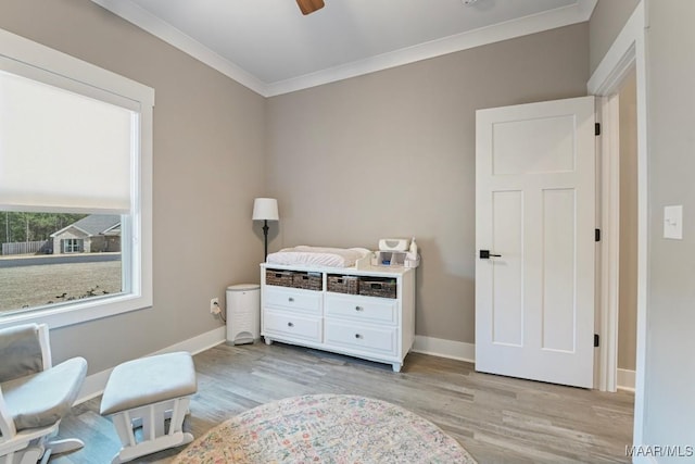 bedroom with baseboards, light wood-type flooring, and ornamental molding