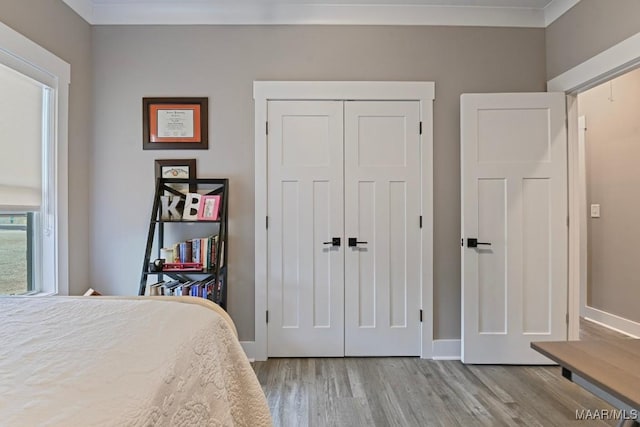 bedroom featuring a closet, baseboards, and wood finished floors