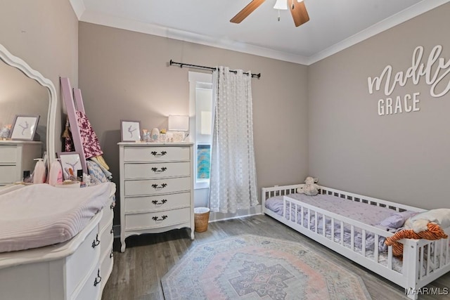 bedroom with crown molding, wood finished floors, and ceiling fan