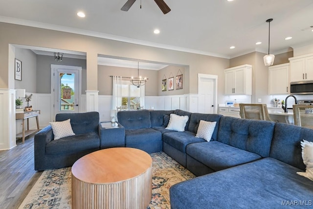 living area featuring a wainscoted wall, recessed lighting, light wood-type flooring, and ornamental molding