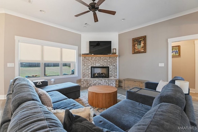 living area featuring a brick fireplace, crown molding, baseboards, and wood finished floors