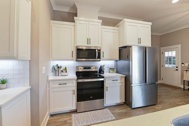 kitchen featuring light wood-type flooring, white cabinets, appliances with stainless steel finishes, crown molding, and tasteful backsplash