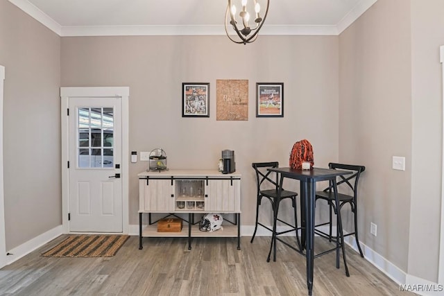 dining space with a chandelier, crown molding, and wood finished floors