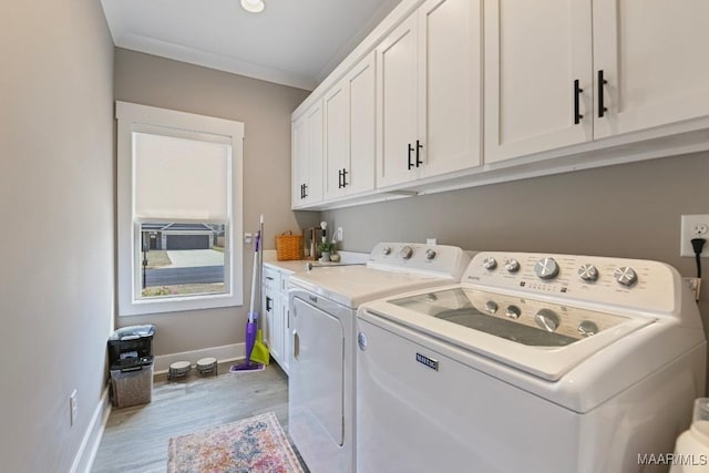 laundry room with baseboards, light wood-style flooring, cabinet space, ornamental molding, and washing machine and dryer