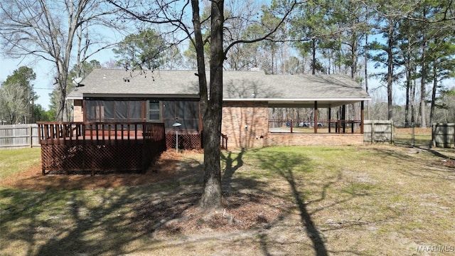 rear view of house featuring brick siding, fence, a lawn, and a wooden deck