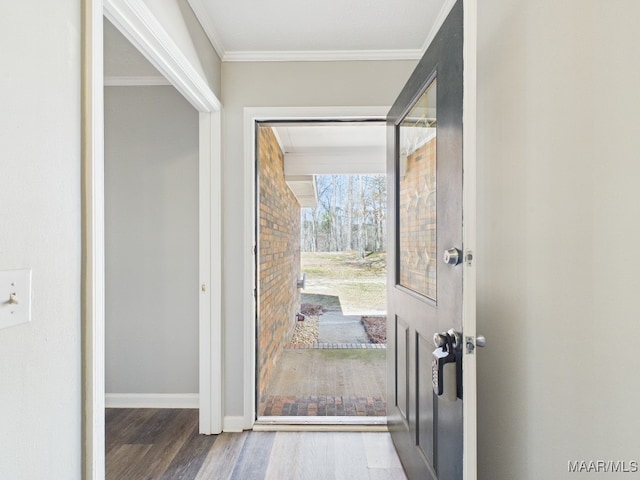 entryway with baseboards, wood finished floors, and ornamental molding