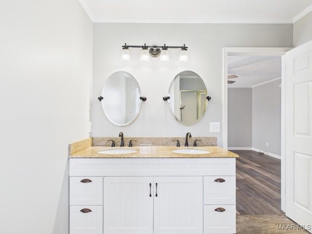 full bath with a sink, wood finished floors, ornamental molding, and double vanity