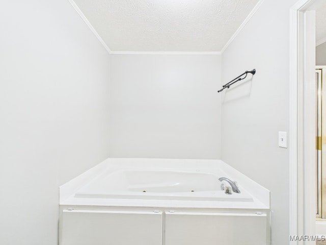 full bath featuring a bath, a textured ceiling, and crown molding