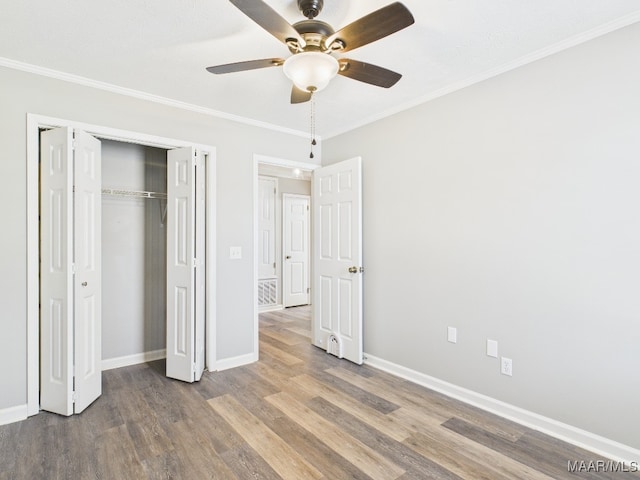 unfurnished bedroom featuring baseboards, wood finished floors, and ornamental molding