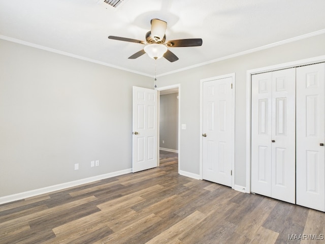 unfurnished bedroom with wood finished floors, baseboards, a closet, and ornamental molding