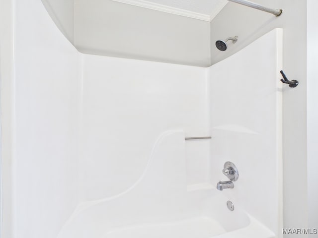 bathroom featuring a textured ceiling, ornamental molding, and  shower combination