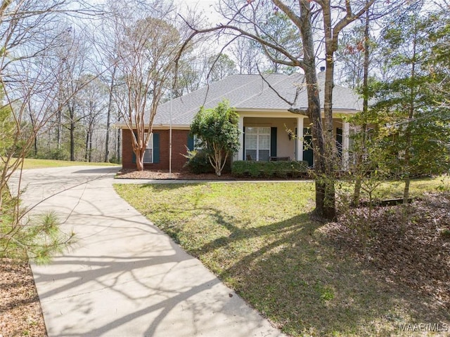 view of front facade with a front lawn, brick siding, and roof with shingles