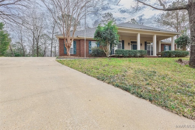 view of front of home featuring brick siding, stucco siding, and a front yard