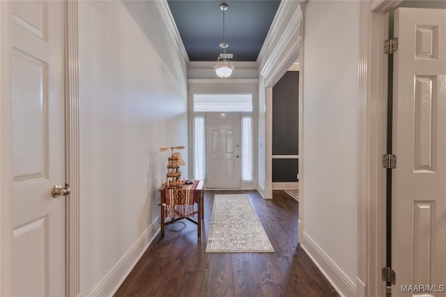 foyer entrance with dark wood finished floors, crown molding, and baseboards