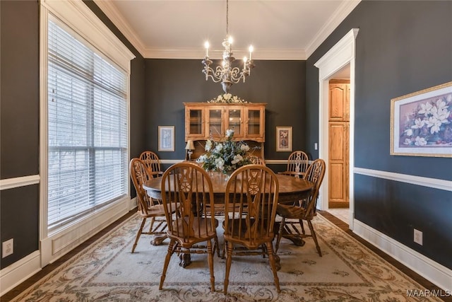 dining space with a chandelier, crown molding, and baseboards