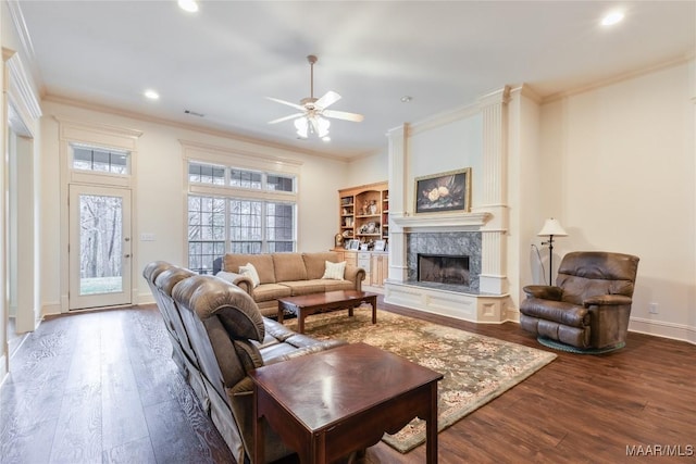 living room with wood finished floors, a fireplace, and ornamental molding